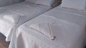 A hotel room with two beds, each with white linens and pillows. - Pousada Sossego Ronaldo e Clarinha  (Santarem)