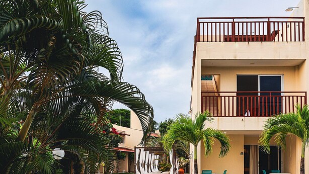 A hotel with a pool, outdoor seating, and a covered area with chairs. - Solar Água Pipa (Tibau do Sul)
