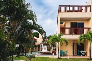 A hotel with a pool, outdoor seating, and a covered area with chairs. - Solar Água Pipa (Tibau do Sul)
