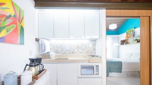 A compact kitchen with a microwave, coffee maker, and a tray with containers. - Solar Água Pipa (Tibau do Sul)