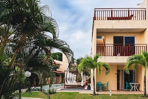 A hotel with a pool, outdoor seating, and a covered area with chairs. - Solar Água Pipa (Tibau do Sul)