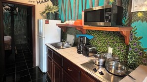 A kitchen with a refrigerator, microwave, coffee maker, and a sink. There is a sign on the wall that says "Where Dreams are Made". - RAINFOREST ROOM - Close to Beach - One Bedroom Suite (San Pedro)