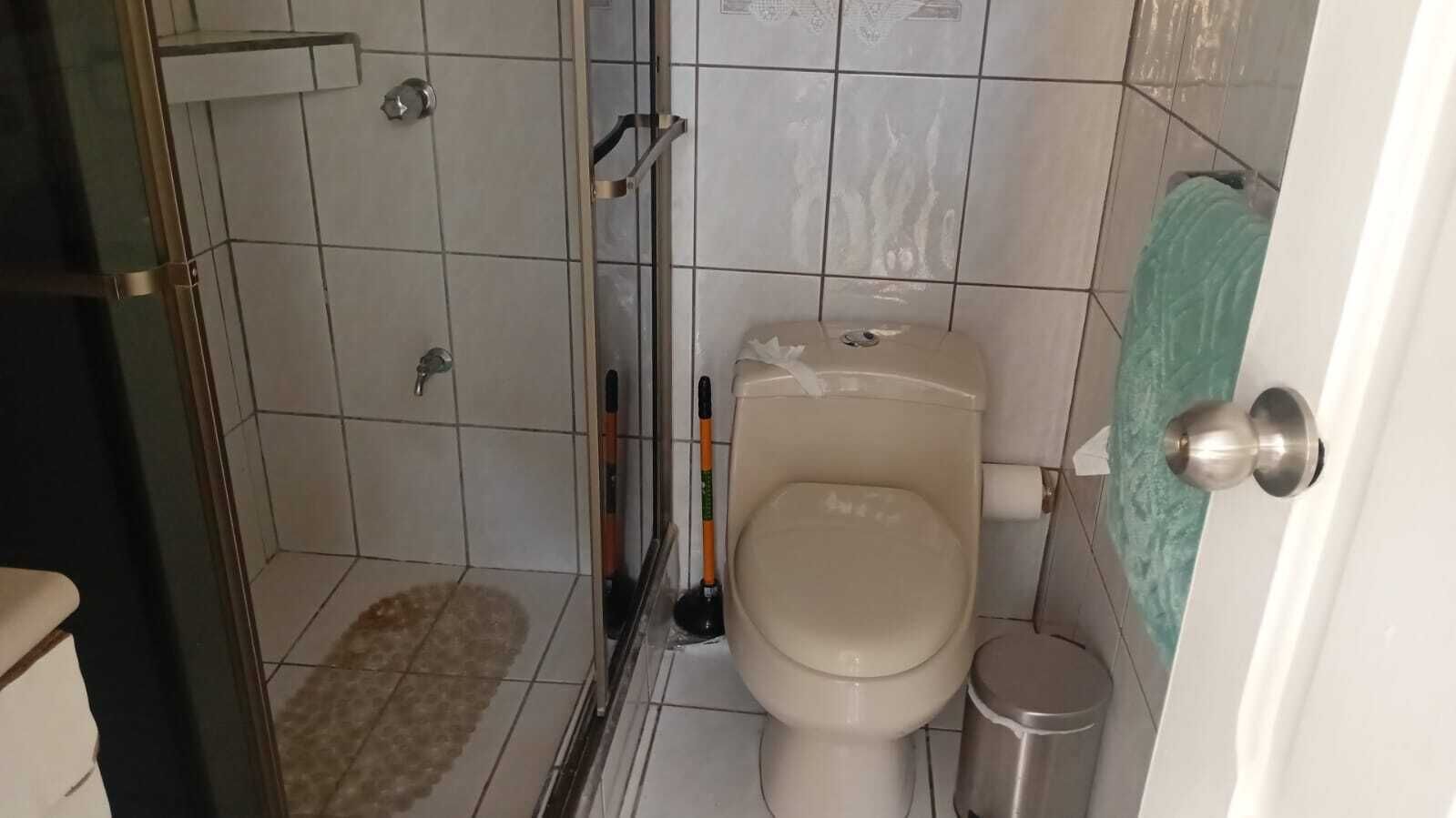 Een douche, handdoeken, zeep, toiletpapier