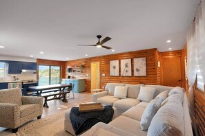 Ein Holzblockhaus-Interieur mit Essbereich, einer Couch und einer Küche.