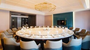 A conference room with a round table, modern chairs, and a chandelier. - Huayuan Hotel (Xiantao)