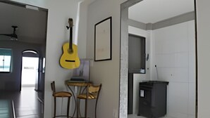 Een moderne keuken met een eethoek, met daarin een gele gitaar, een ingelijst foto en een donker kastje.