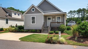 A two-story house with a front porch, a small front yard, and a mailbox.