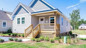 A single-story house with a front porch, a small staircase, and a well-maintained lawn. - OBX Golf & Family Fun Cottage (Powells Point)