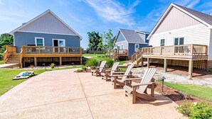A residential area with two houses featuring wooden decks and outdoor seating areas. - Outer Banks Waterpark StaynPlay! (Powells Point)