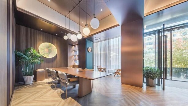 A modern conference room with a wooden table, chairs, and hanging spherical lights.