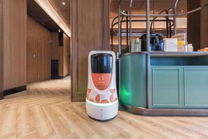 A self-service kiosk in a hotel lobby with a wooden floor and a teal-colored counter. - Orange Hotel (Beijing West Railway Station South Square) (Beijing)