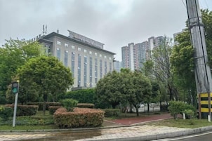 Un edificio de diseño moderno, rodeado de vegetación y un sendero para peatones.