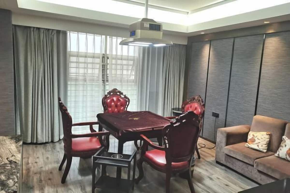 Un comedor moderno con una mesa y sillas, un sofá y un ventanal con cortinas.