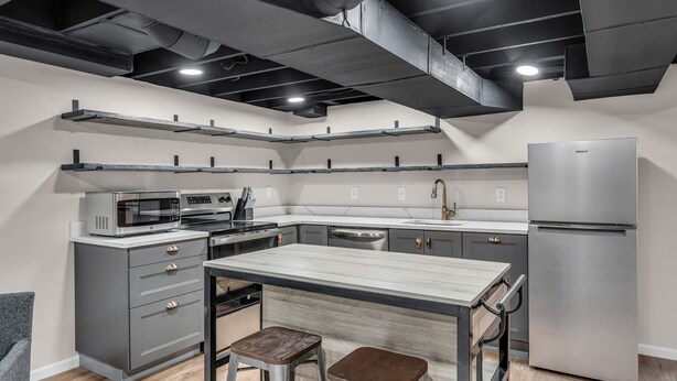 Een moderne keuken met een ingebouwde magnetron, oven en een roestvrijstalen koelkast.