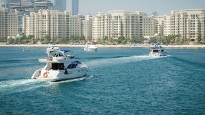 A waterfront hotel with multiple high-rise buildings in the background. - Family & Friends HUGE House Dubai MALL Fast Ride (Dubai)