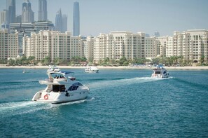 A waterfront hotel with multiple high-rise buildings in the background. - Family & Friends HUGE House Dubai MALL Fast Ride (Dubai)