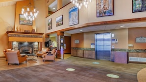 A lobby with a fireplace, seating area, and a reception desk. - NFL Draft or Easter week condo with indoor waterpark (Wisconsin Dells)