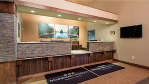 A reception area with a stone counter, wooden paneling, a large window with a view, and a flat-screen TV on the wall. - NFL Draft or Easter week condo with indoor waterpark (Wisconsin Dells)