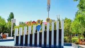 A sign with multiple symbols and text, surrounded by a fence with vertical bars. - IU Hotel Yining Shanghai City (Yining City)