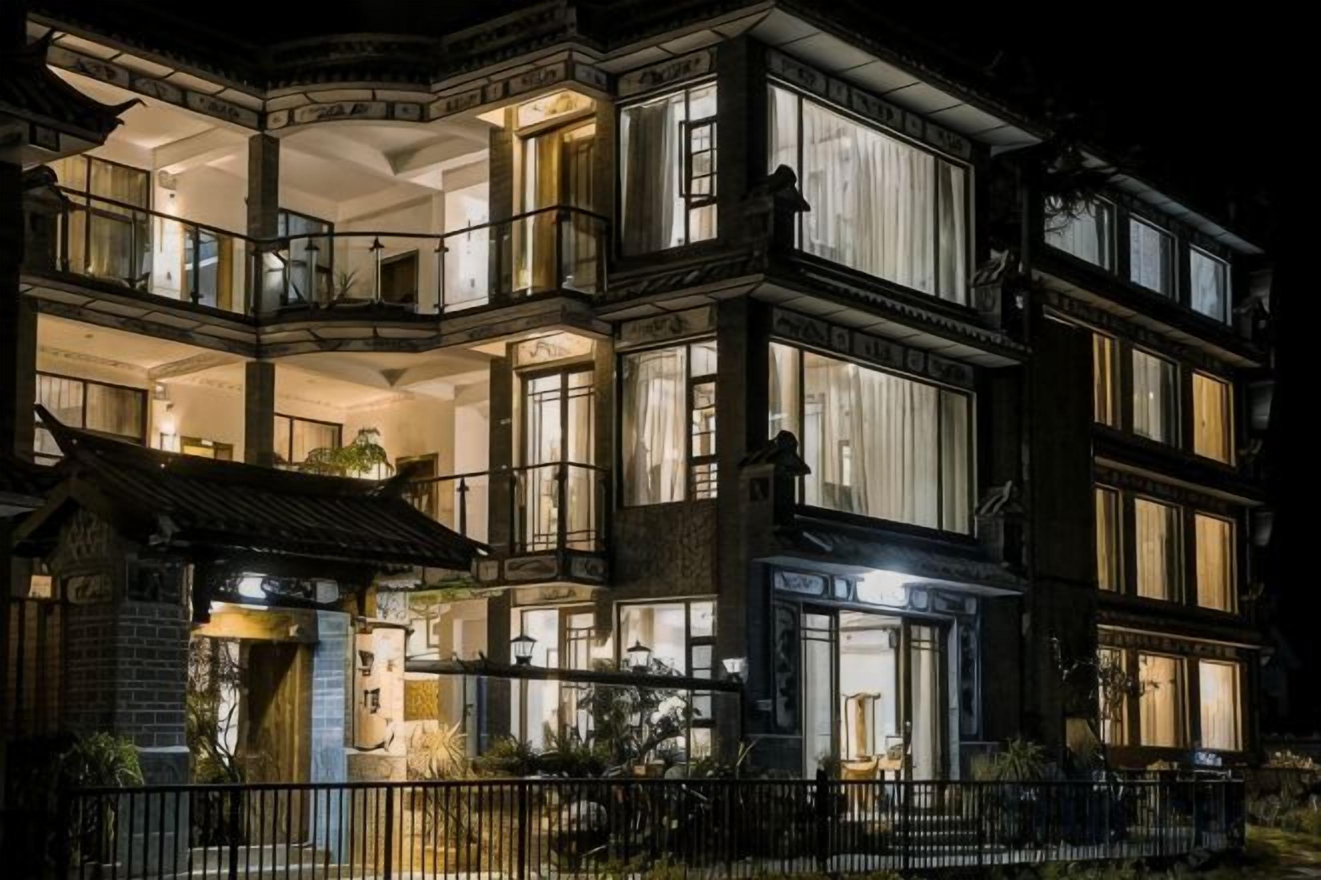 Un edificio de varios pisos con balcones, ventanas amplias y una entrada bien iluminada.