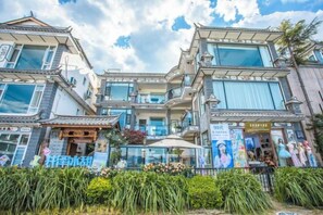 A multi-story building with a traditional architectural style, featuring large windows and a balcony. - Longkan Yunding Courtyard Hotel (Dali City)