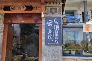 A traditional Chinese building entrance with a stone archway and a signboard. - Longkan Yunding Courtyard Hotel (Dali City)