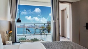 A hotel room with a bed, a small table, and a view of the sea. - Longkan Yunding Courtyard Hotel (Dali City)