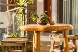 A wooden table with a bowl and potted plants, accompanied by matching wooden benches. - Longkan Yunding Courtyard Hotel (Dali City)