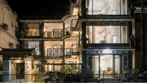 A multi-story building with traditional architectural elements, balconies, and large windows. - Longkan Yunding Courtyard Hotel (Dali City)