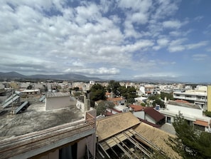 A cityscape with buildings, a clear sky, and distant mountains. - Terminal Square Suites (Markopoulo Mesogaias)