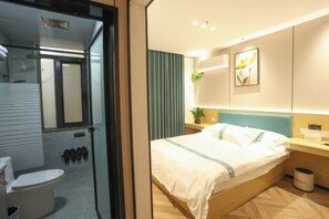A modern hotel room with a bed, bedside table, and a view of the bathroom. - Shanghai Xinnuo Hotel (Shanghai)