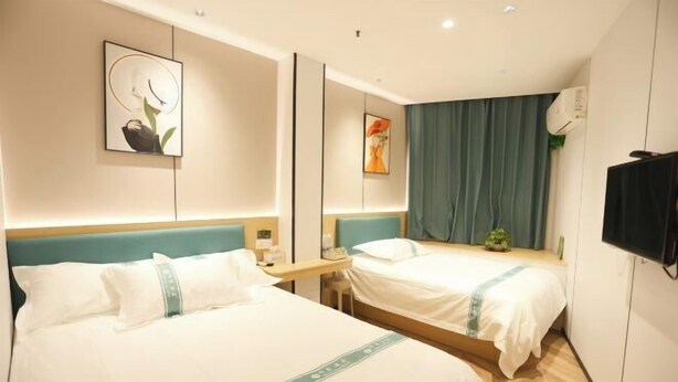 A hotel room with two beds, a flat-screen TV, a desk, and artwork on the walls. - Shanghai Xinnuo Hotel (Shanghai)