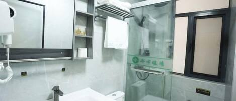 Un baño moderno con lavamanos, espejo y cabina de ducha de vidrio.