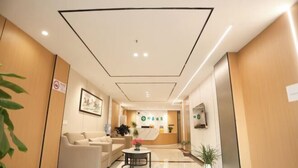 A hotel reception area with a reception desk, a waiting area with sofas, and a reception counter. - Shanghai Xinnuo Hotel (Shanghai)