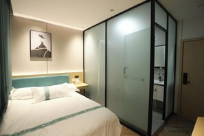 Una habitación de hotel con una cama, una mesita de noche, un armario y un cuadro en la pared.