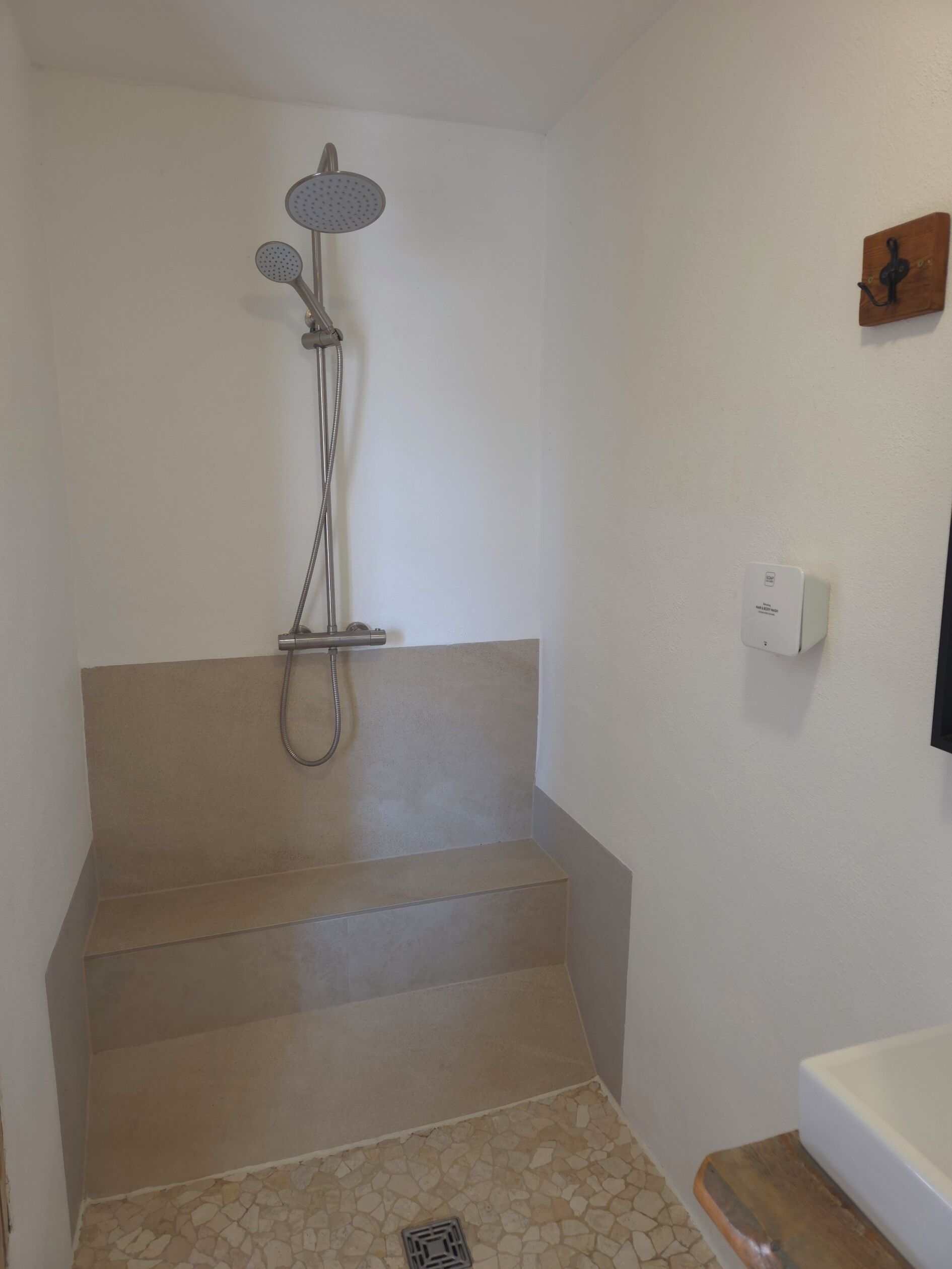 Une salle de bain avec une douche, des toilettes et un lavabo.