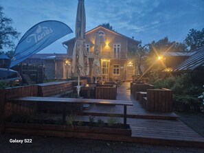 A wooden deck with outdoor seating and a building with a sign reading "Taevasa."