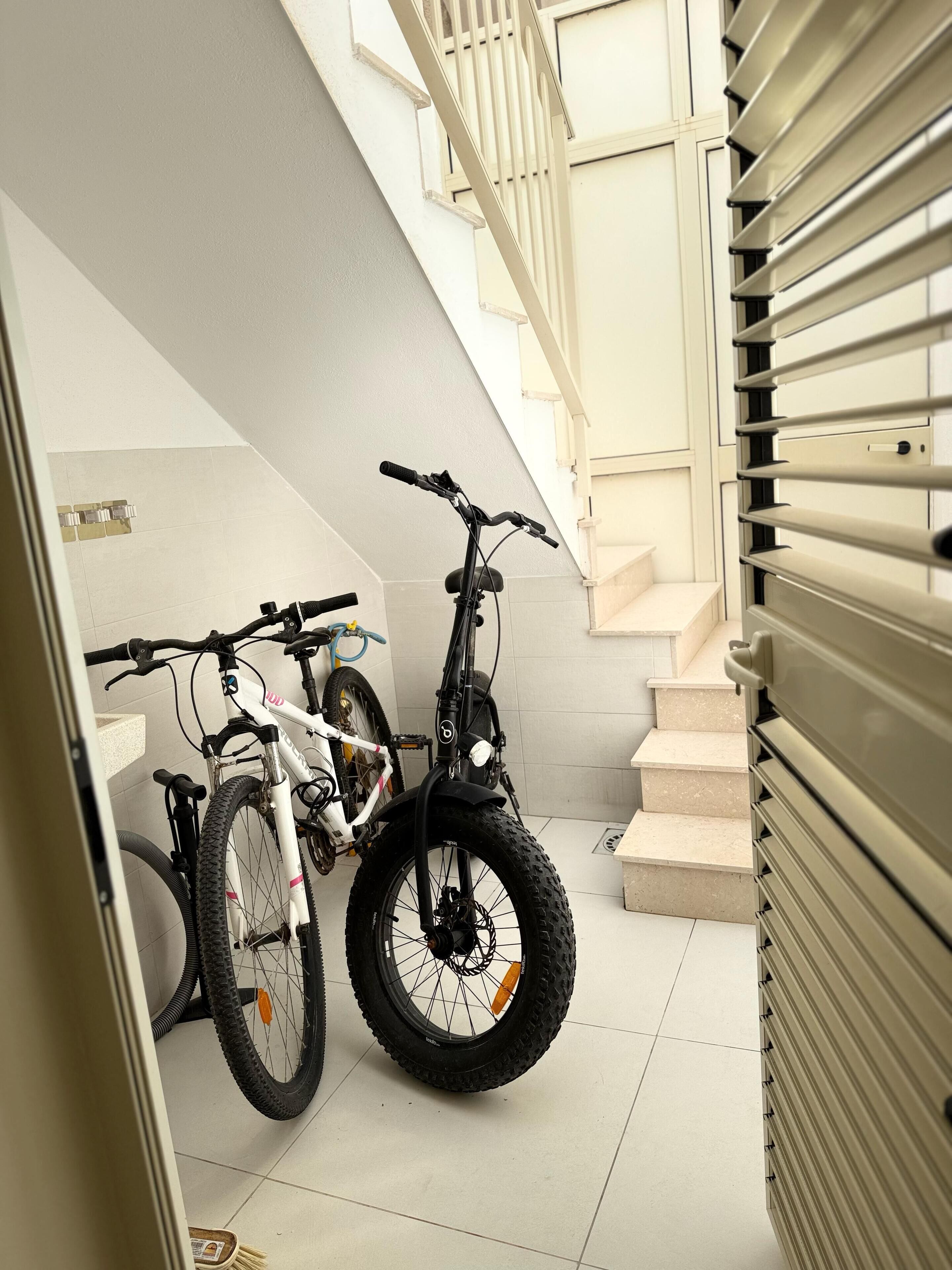 A staircase with a handrail and a door with a metal handle.