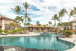A pool area with lounge chairs and palm trees. - Lux Retreat 3BR (Waikoloa)