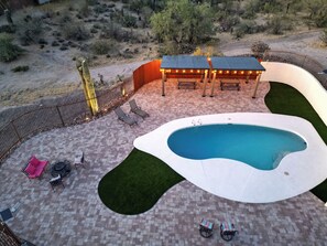 A swimming pool with a surrounding patio area, a covered seating area, and a fenced perimeter. - Long Stay Ready  Quiet  Fast WiFi (Tucson)