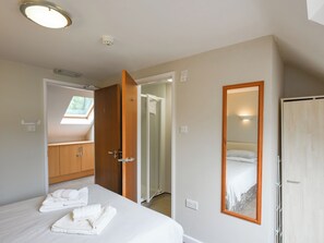 A hotel room with a bed, a bathroom, and a wardrobe. - The Garden Lodge Flat - UK49415 (LLanteg, near Narbeth)