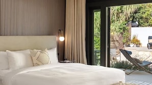 A modern bedroom with a large bed, a wooden bench, and a view of the outdoors. - Hollywood Hills Villa by Universal-Pool-Dogs OK (Los Angeles)