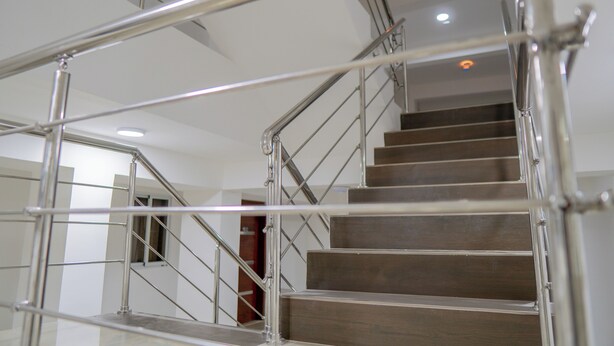 Una escalera moderna con barandillas de metal y peldaños de madera.