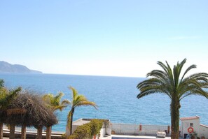 A coastal view with a clear sky, a body of water, and palm trees. - Carabeo 24 Apartment by Casasol (Nerja)