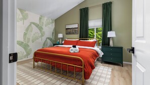 A bedroom with a bed, green curtains, a window, a nightstand, and a ceiling fan. - 4bdr 2 bath house. Unwind in the hot tub, chat around the fire pit and disc golf (Traverse City)