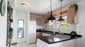 Une cuisine moderne dotée d’un îlot central, de meubles en bois et d’une grande fenêtre offrant une vue sur la ville.