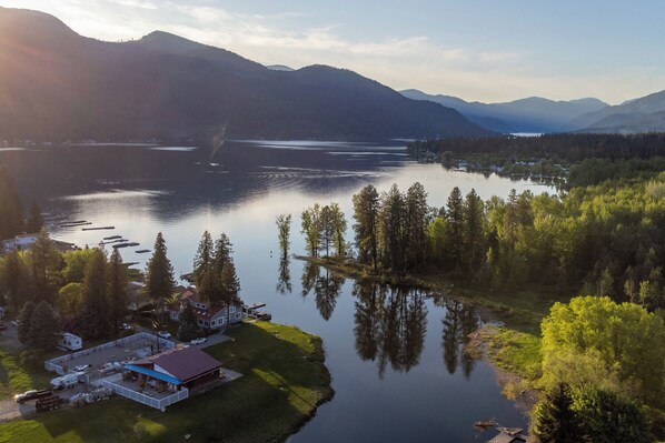 Una propiedad junto al lago con una casa grande, muelle y bosque circundante.