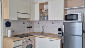 A modern kitchen with a built-in oven, microwave, and refrigerator.