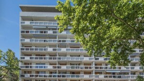 A multi-story building with balconies, a parking area, and trees in the foreground. - Charming T4 with parking and terrace - sleeps up to 6 (Avignon)