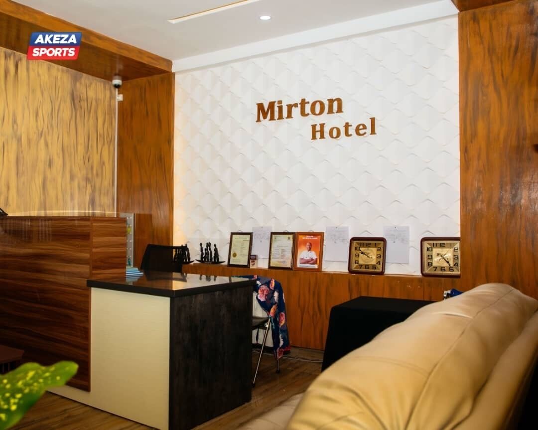 A reception area with a wooden reception desk, a clock, and framed certificates on the wall.